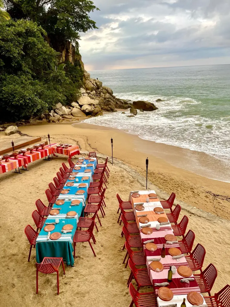 A long dinner table set on the beach for the retreat group
